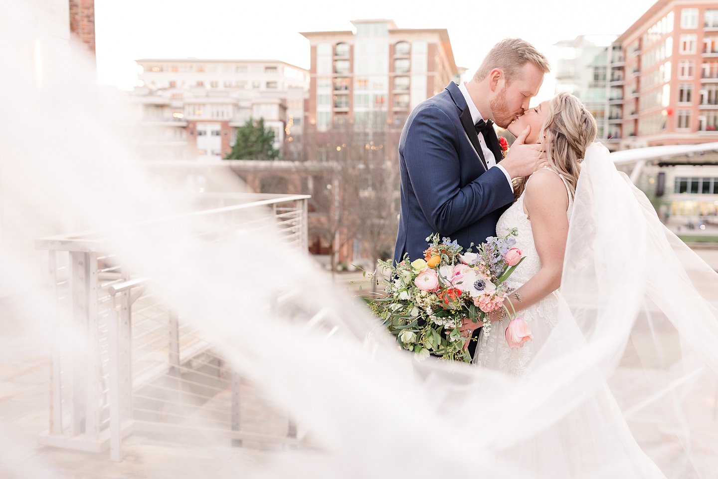 downtown Greenville bride and groom portrait with veil flying